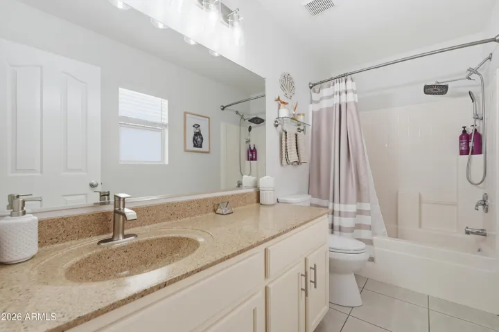 Well-appointed guest bathroom featuring an extended vanity with ample counter space and a tub/shower combination, offering both comfort and functionality for guests.