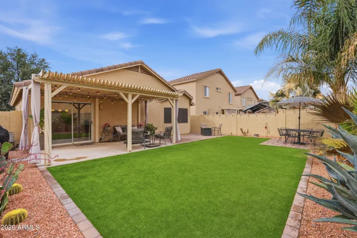 Spacious backyard offering a blend of turf and paver areas, ideal for entertaining, dining, or enjoying Arizona outdoor living