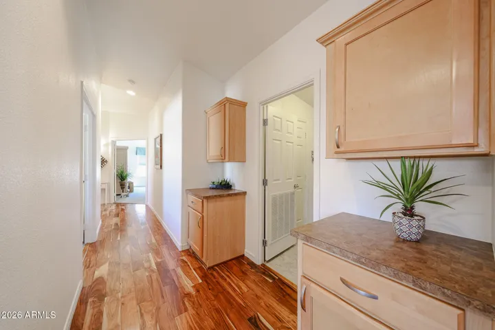 Hallway has linen cabinets and acacia flooring