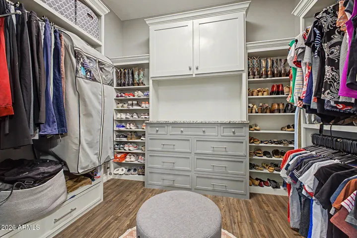 Primary bedroom has two walk in closets with custom shelves and drawers.