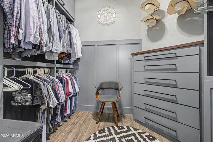 Primary bedroom has two walk in closets with custom shelves and drawers.
