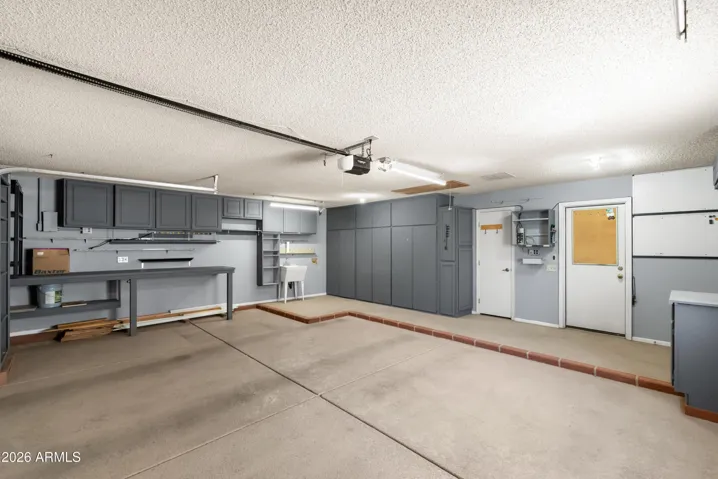 with built in cabinets, work bench & utility sink. Side door to backyard.
