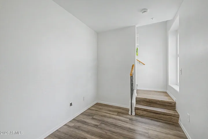 Interior foyer with wood-look flooring, neutral paint, and staircase leading to the second level