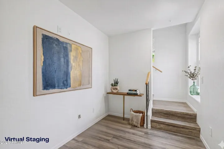 Interior foyer with wood-look flooring, neutral paint, and staircase leading to the second leve