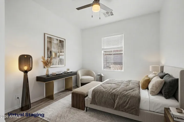 Bright bedroom with updated wood-style floors, walk-in closet and a ceiling fan. A single window provides natural light, and the simple layout offers flexible use.
