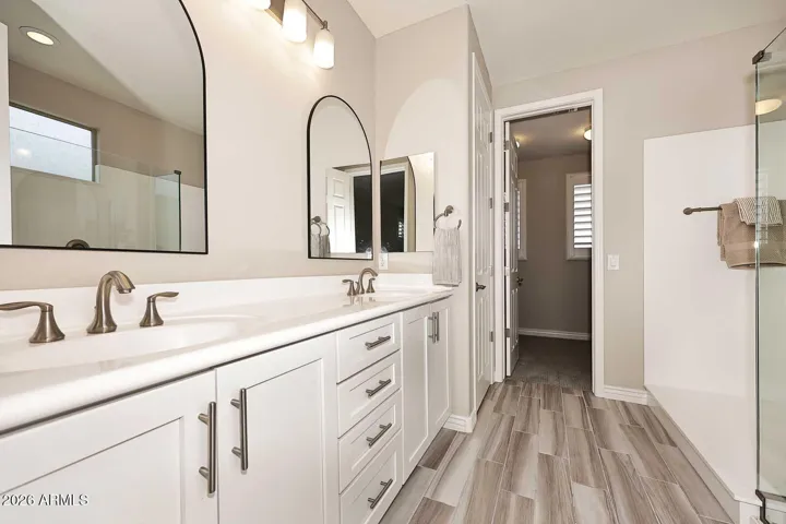 Features double vanity, linen closet, walk-in shower with drying area, and water closet.