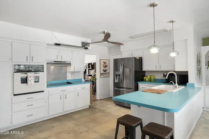 Awesome kitchen with wall oven and stainless steel fridge.