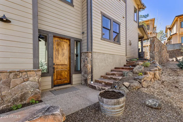 Front entry with beautiful stone bench/steps and lighted stairway to back yard, adjacent to open common area.