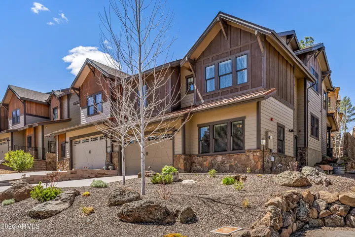 Beautiful front elevation of home with newly designed hardscape and lush mountain landscape.