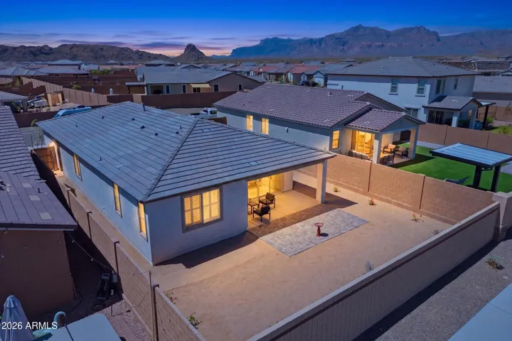 Twilight aerial showcasing the private backyard, paver patio, and no rear neighbors with mountain views.