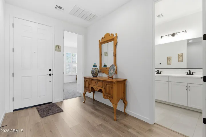 Entryway with tile flooring and open view into the home, with nearby access to a guest bathroom.
