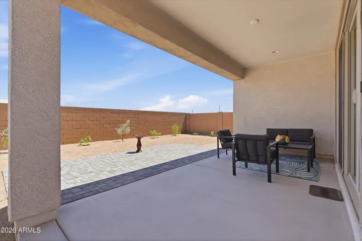 Covered patio with paver extension for outdoor seating.
