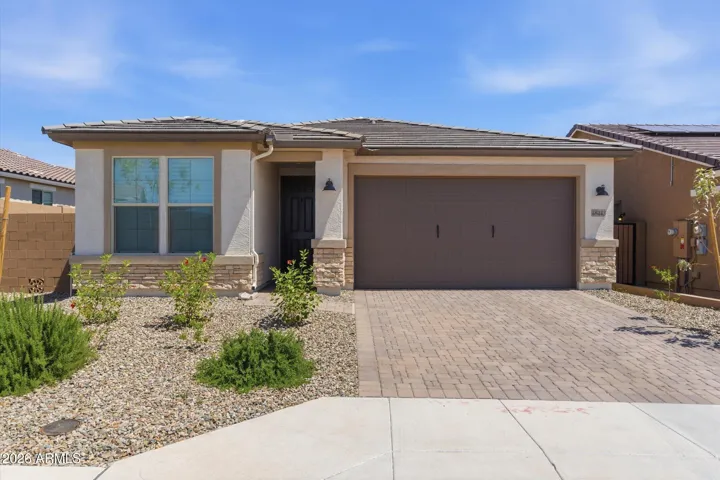 Clean curb appeal with upgraded elevation, paver driveway, and low-maintenance landscaping.