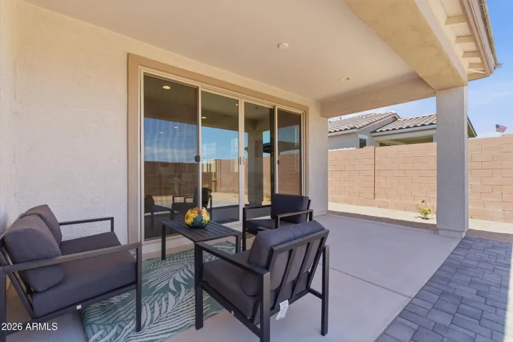 Covered patio with paver extension for outdoor seating.