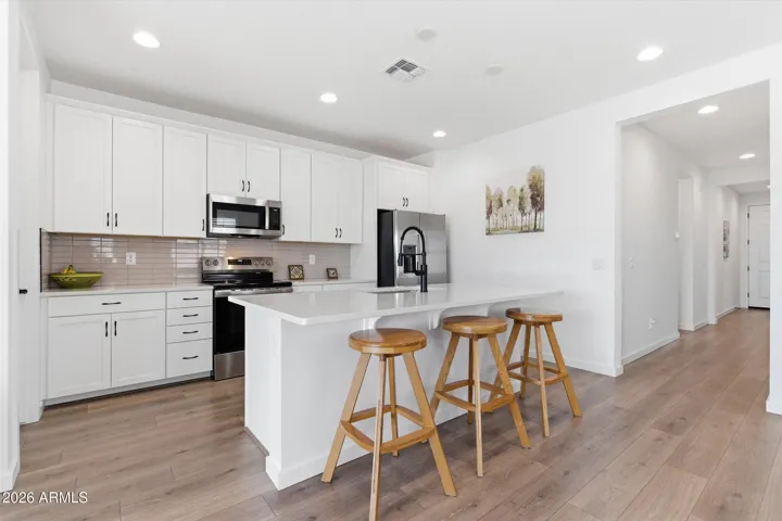 Large kitchen with center island, stainless steel appliances, and ample cabinetry.