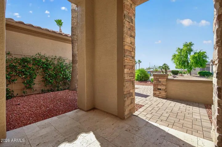 Pavers and travertine enhance the front courtyard.