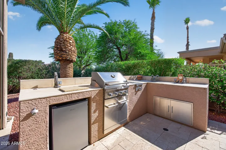 The outdoor kitchen offers a refrigerator, storage & a seering plate for the perfect seer on your food.