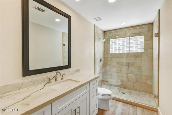 Guest bath with tile shower, granite counters and shaker cabinets