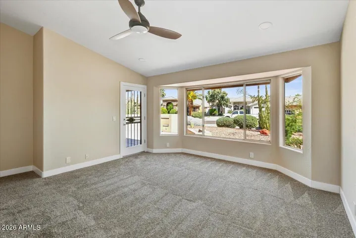 Primary bedroom with bay window, fresh carpeting and private patio access