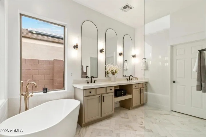 Marble tile floors with walk in shower and soaking tub in primary bathroom