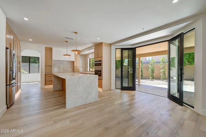 Custom Doors Open to Patio off Family Room and Kitchen Brings the Outside In While Sitting at 9-Ft Waterfall Island
