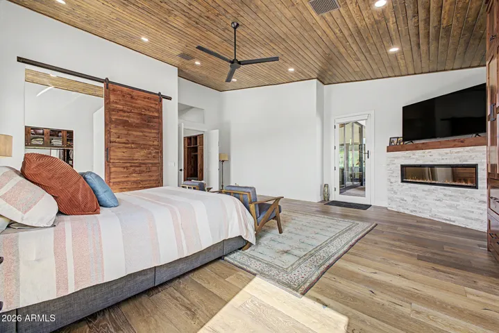Luxurious primary bedroom with electric fireplace