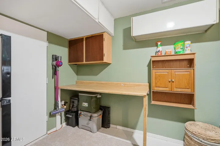 Storage and a folding table are great additions to this laundry area. There is also a bonus fridge in this room.