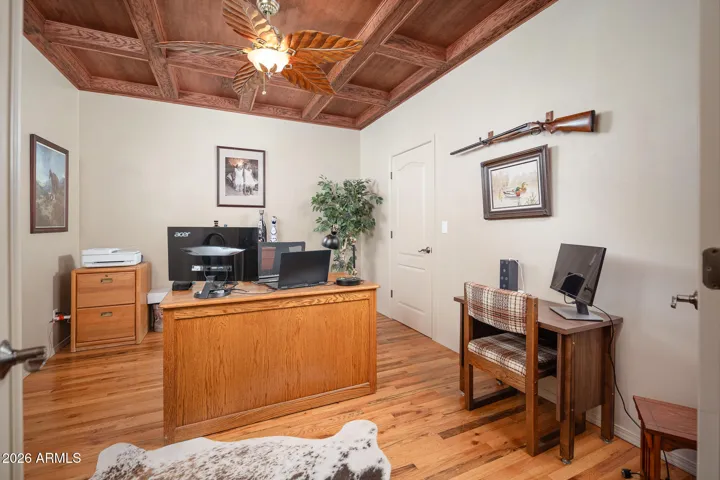 Den with coffered ceiling with view front yard