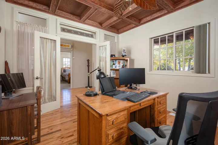 Den with coffered ceiling with view front yard