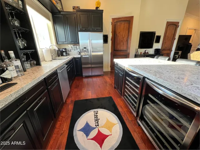 Full size refrigerator, sink, dishwasher, 2 wine refrigerators, bar area, cabinets