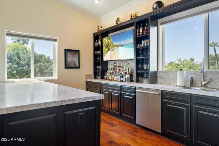 Full size refrigerator, sink, dishwasher, 2 wine refrigerators, bar area, cabinets