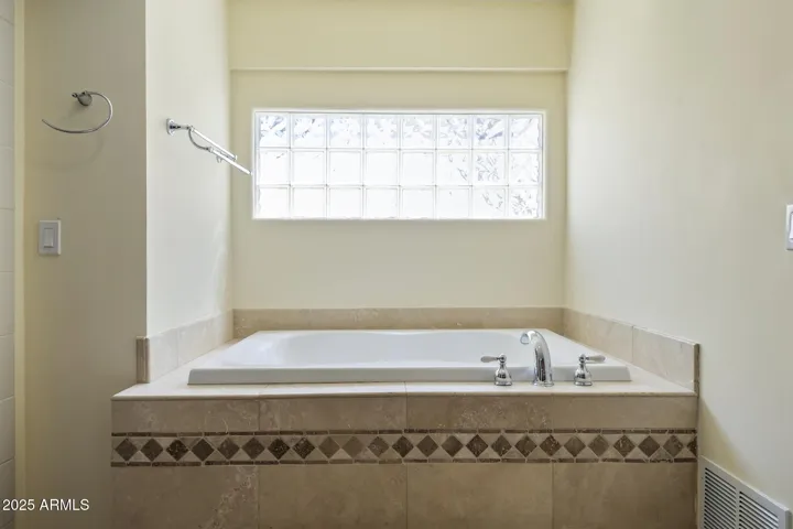 1st floor primary ensuite bathroom with separate tub and shower