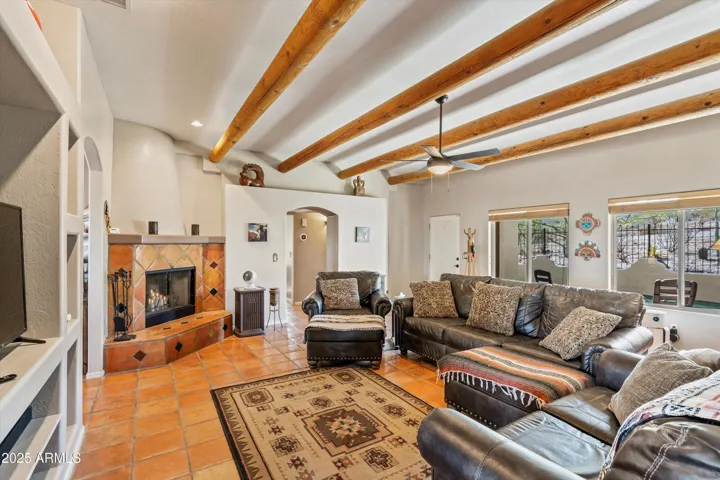 The southwestern feel continues with the wood beams and rounded fireplace