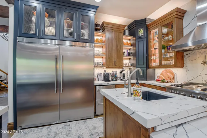 Built in fridge-freezer with glass shelves and metal mesh lighted storage to display whatever you choose!