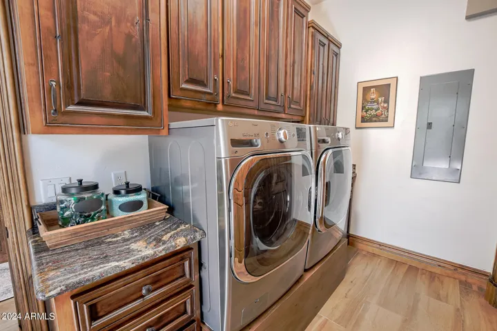 Sink to the right of the dryer with tons of alder cabinetry.