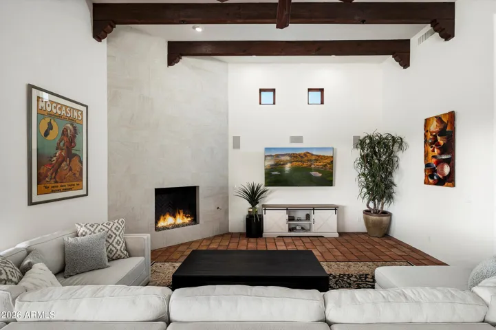 Cozy corner fireplace with wood beam ceiling