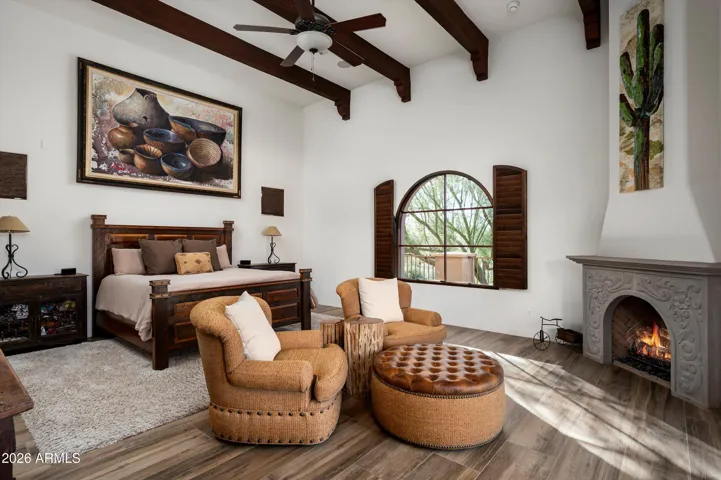 Large Primary Suite with corner fireplace, sitting area and French doors to patio