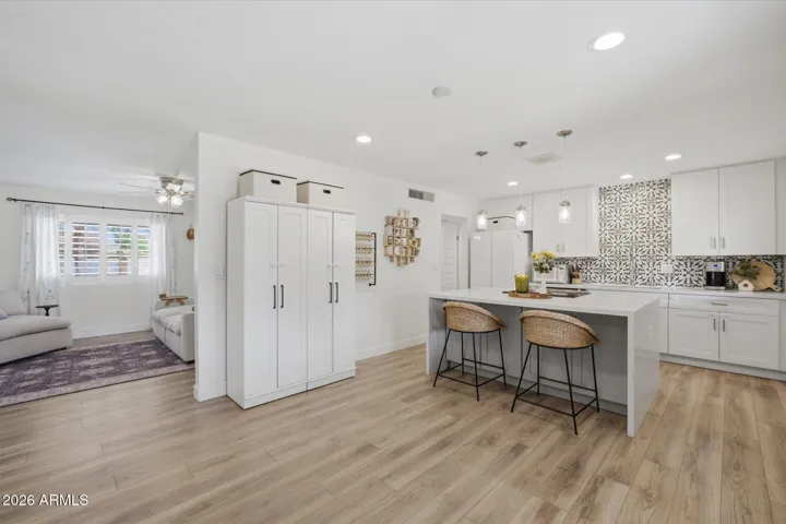 Completely remodeled home. Updated kitchen with elongated white shaker style cabinetry, quartz countertops, waterfall island, decorative tile backsplash, and stainless appliances.
