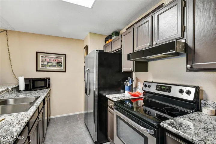 Open kitchen with granite counters and stainless steel appliances