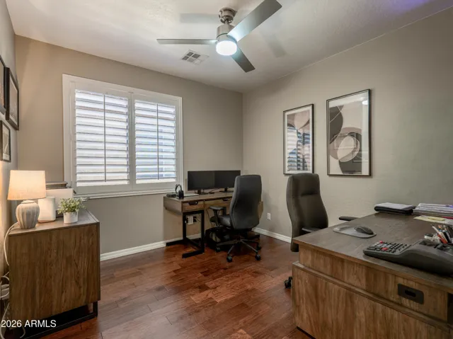 Bedroom four with hard floors, shutters, and ceiling fan