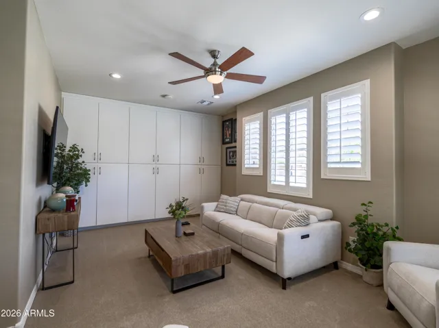 Secondary living space with plush carpet and built-in storage cabinetry