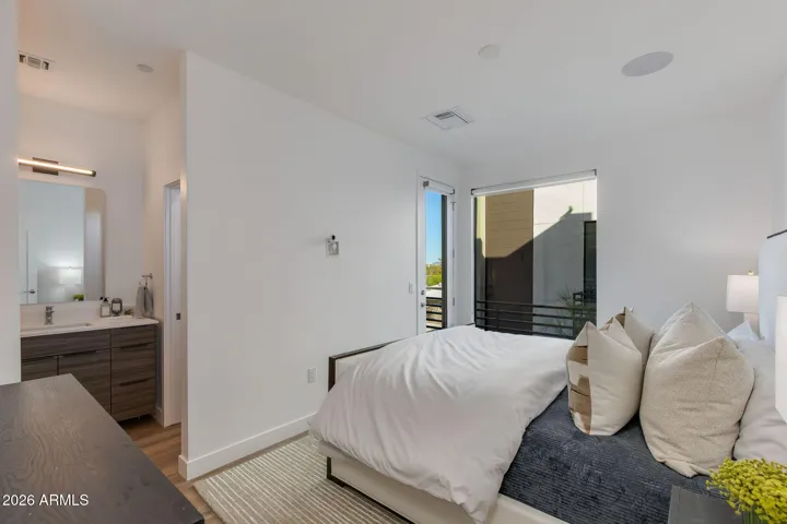 Has full en-suite access with a walk-in closet and bathroom with dual vanities, toilet, and shower.