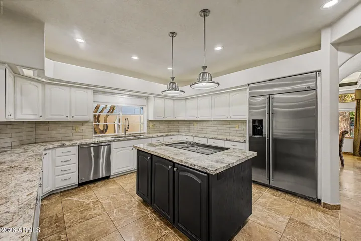Wall-to-wall Cabinetry | Center island with additional Cabinetry | Sub-Zero Refrigerator | Granite Countertops |Full Tile Backsplash | Tinted Bay Window