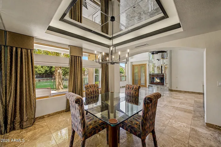Custom Chandelier | Coffered Mirrored Ceiling with Integrated Lighting | Pella Windows Showcasing Lake Views | Mirrored Accent Wall