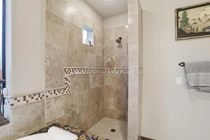Spacious shower clad in stone....a perfect place to start the day