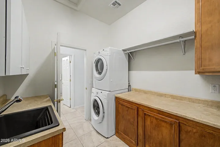 LARGE Laundry room with plenty of cabinets, folding table, hanging rod and utility sink!