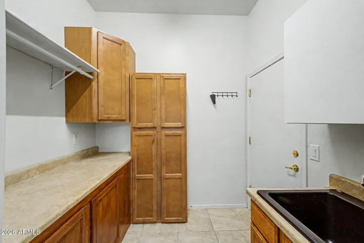 LARGE Laundry room with plenty of cabinets, folding table, hanging rod and utility sink! - Door to Garage