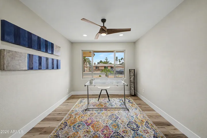 Bright front-facing flex room with large picture window, modern lighting, and versatile space ideal for a home office, den, or sitting room.