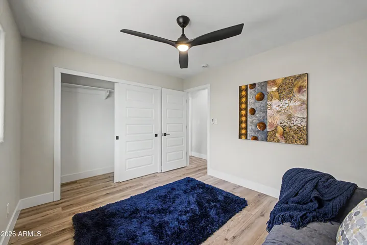 Stylish guest bedroom with modern sliding closet doors, upgraded flooring, and clean contemporary design.