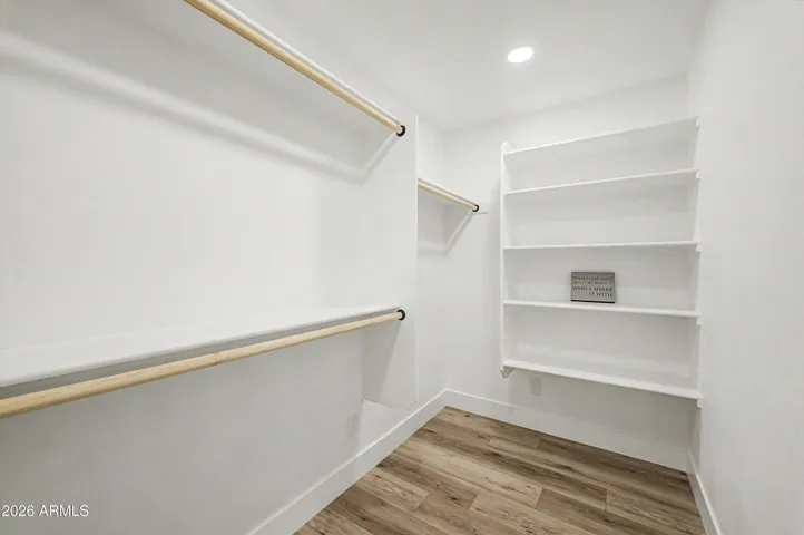 Huge walk-in closet with custom shelving, abundant hanging space, and built-in storage for maximum organization.